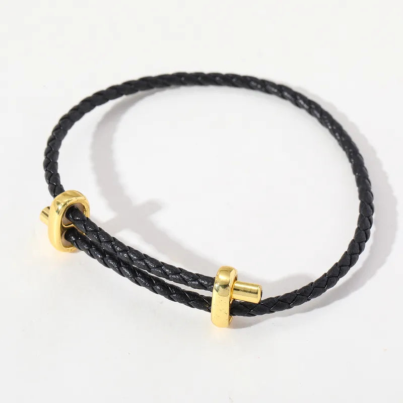 Schwarzes geflochtenes Lederarmband mit goldfarbenen Details.