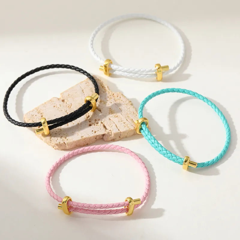 Set aus vier Lederarmbändern in Schwarz, Rosa, Türkis und Weiß mit goldfarbenen Details, dekoriert mit Stein.