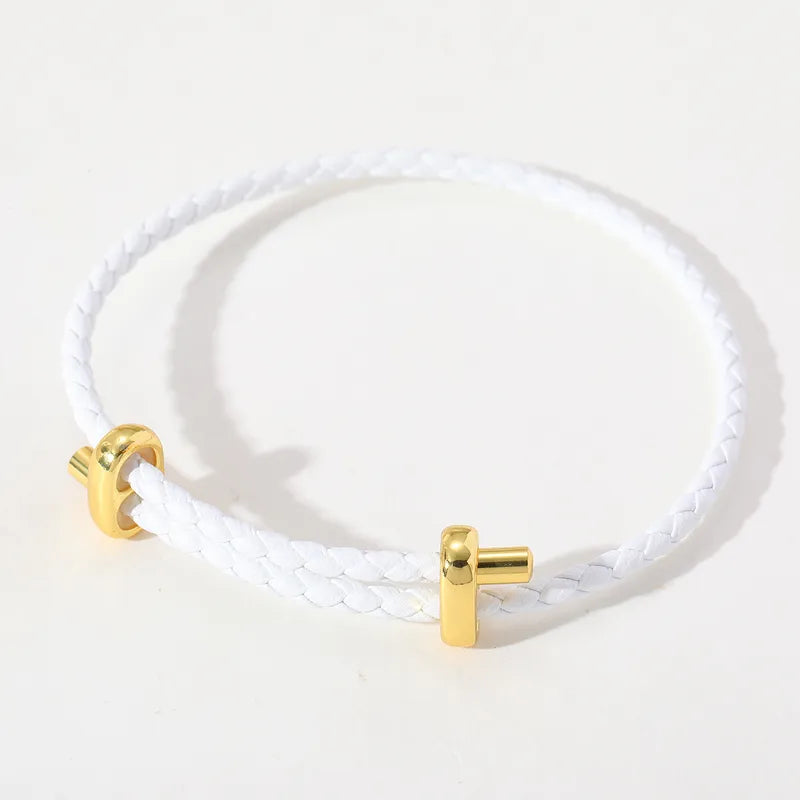Weißes geflochtenes Lederarmband mit goldfarbenen Details.