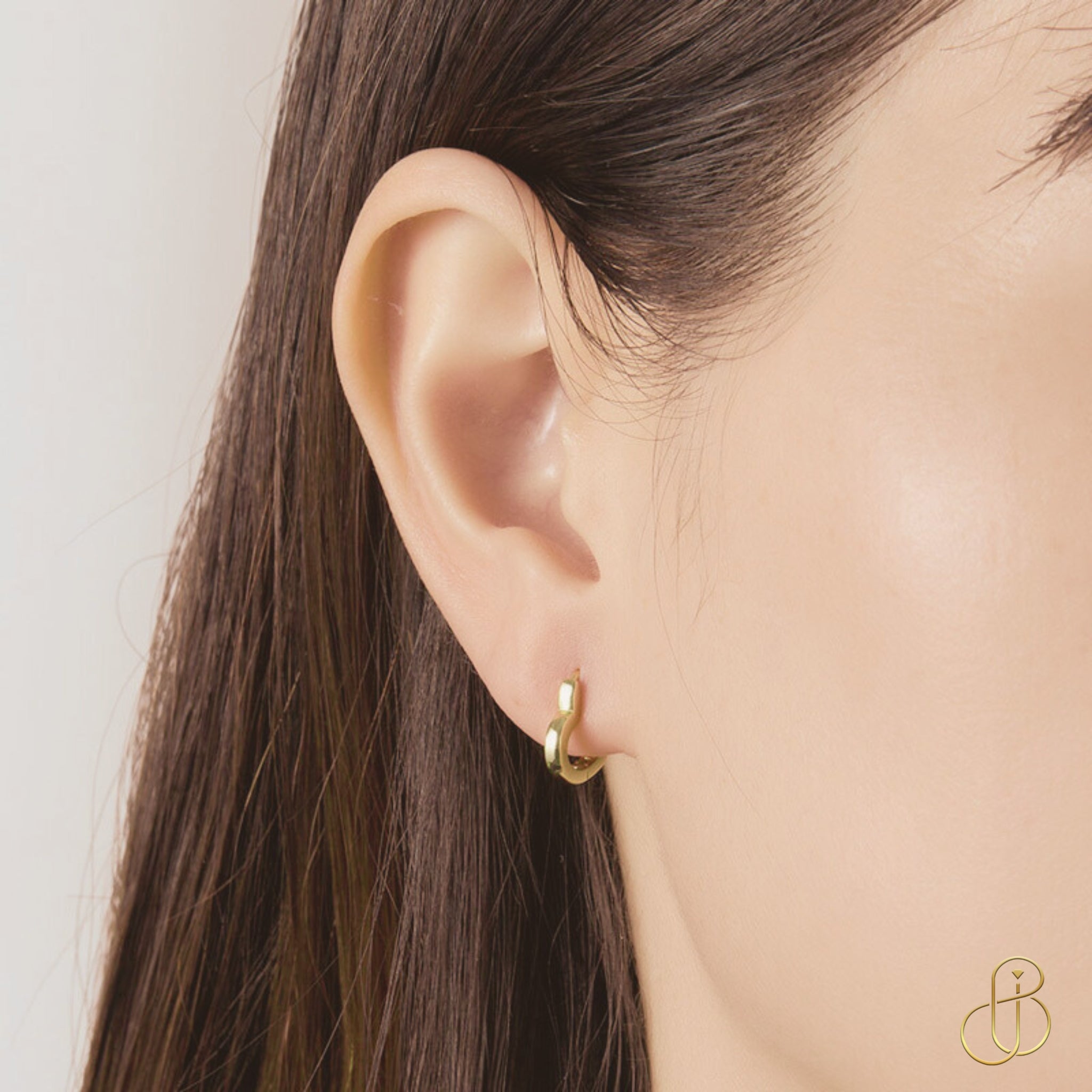 Vergoldete Herz-Creole aus 925 Sterling Silber am Ohr getragen, dezenter und eleganter Schmucklook.