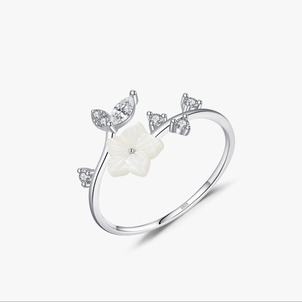 Offener Blumenring aus 925 Silber mit Perlmuttblüte & funkelnden Zirkoniasteinen – auf weißem Hintergrund.