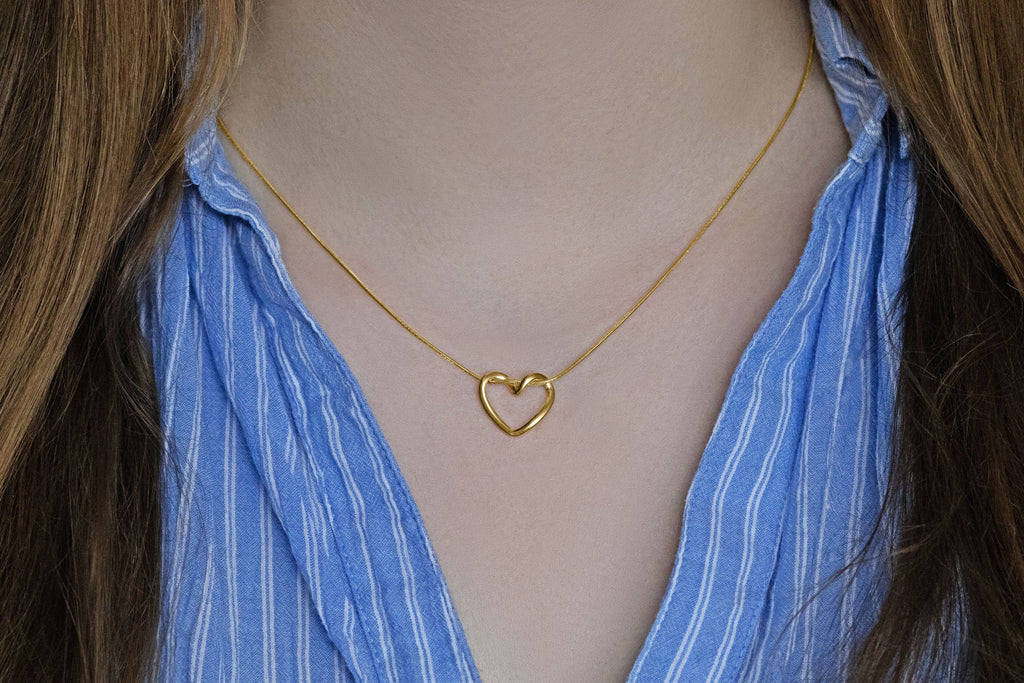 Minimalistische Herz-Kette vergoldet getragen am Hals eines Models