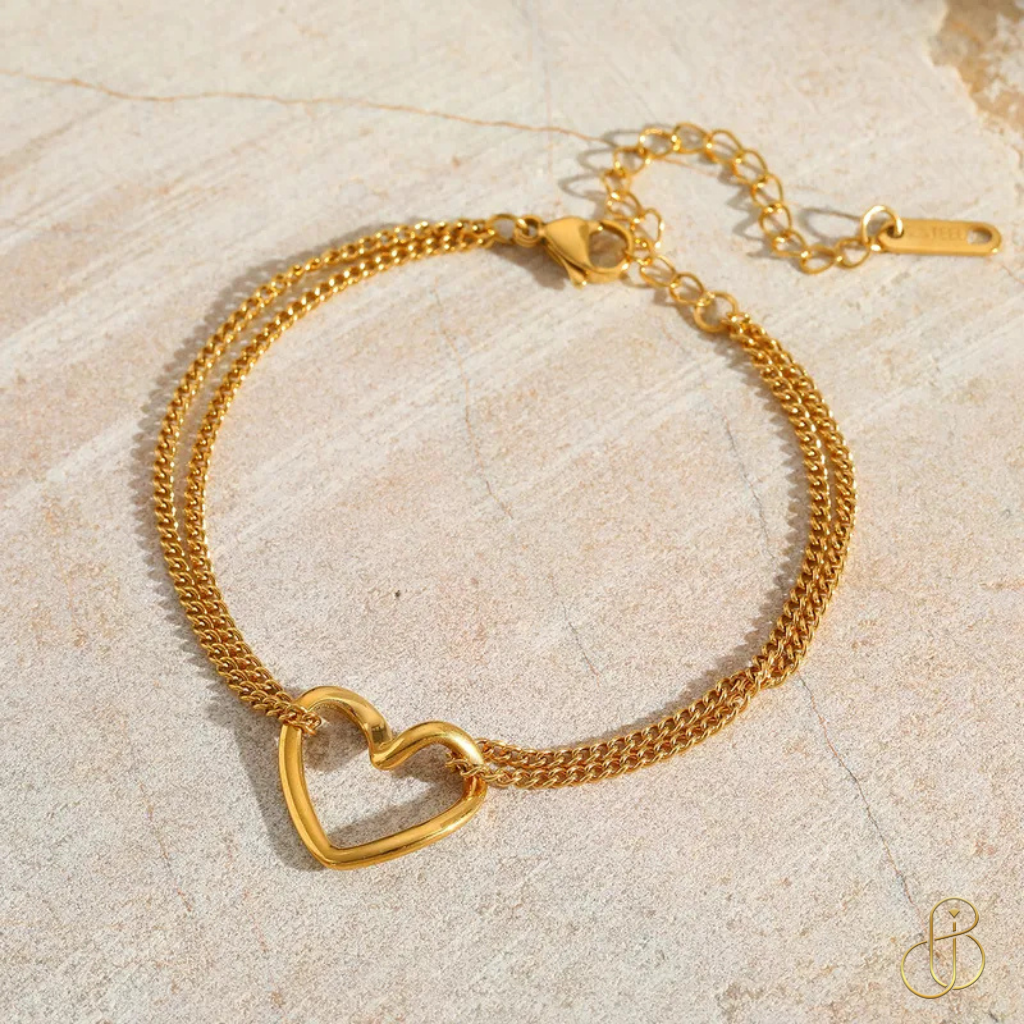 Elegantes Herz-Armband Ella – 18K vergoldet, Edelstahl 304 & Kupfer – goldene Variante auf hellem Stein-Hintergrund.