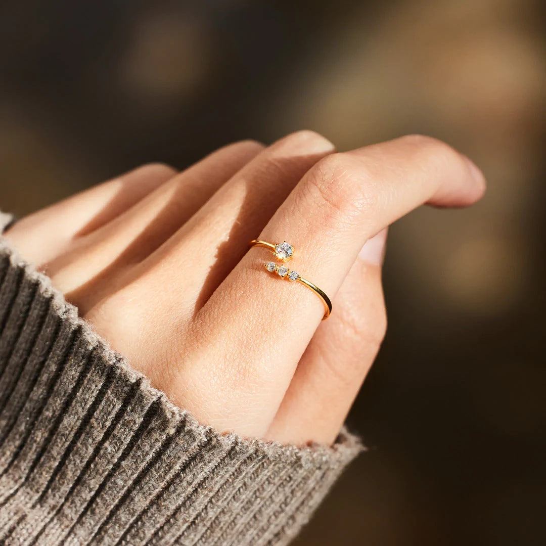 Filigraner Damenring in Goldoptik mit funkelnden Zirkonia – elegant getragen an der Hand.