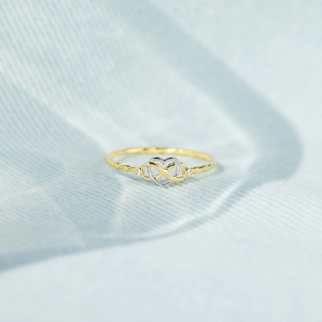 925 Silberring mit goldfarbener Oberfläche und verschlungenem Herzdesign – Symbol für Liebe und Unendlichkeit.