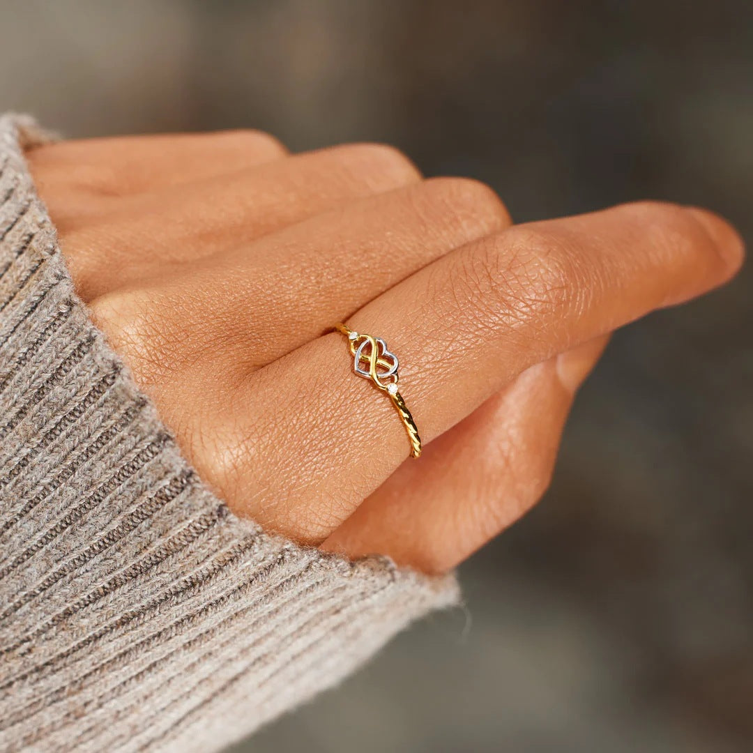 Feiner Damenring mit Herz- und Unendlichkeitsmotiv – stilvoller Schmuck an der Hand.
